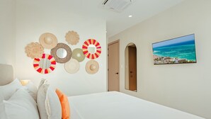 Ein Hotelzimmer mit einem Bett, einer Wand mit dekorativen Spiegeln und einem Gemälde einer Küstenlandschaft.