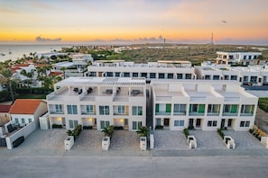 Un hotel moderno con varios pisos, ventanas amplias y techo plano.