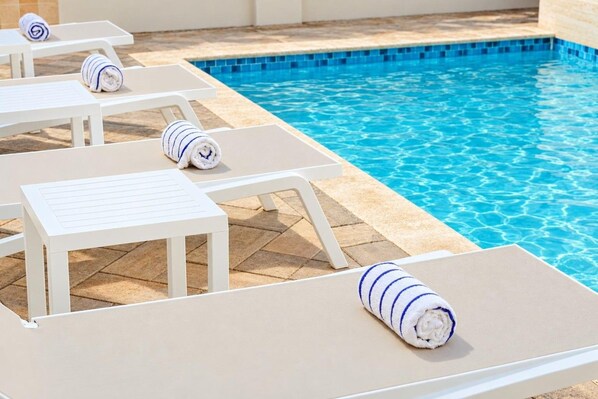 A poolside area with lounge chairs and towels.