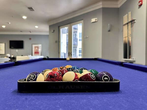 A pool table with a variety of colored balls and a black tablecloth.