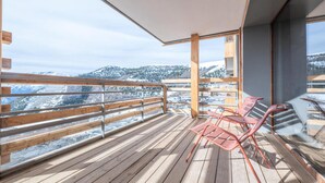 A balcony with wooden flooring and metal railings, overlooking a snowy mountain landscape. - Beautiful new Apartment, Close to the Slopes (Huez)