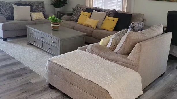 A modern living room with a grey sofa, a beige sofa, and a coffee table. There is a plant on the coffee table and a painting on the wall. - The Pool House at East Mesa close to Superstition Mountain, Goldfield Ghost town (Mesa)