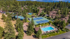 An aerial view of a residential area with houses, a tennis court, and a swimming pool.