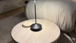 A round wooden table with a black lamp, a white cushion, and a small wooden object on the table. - Black Diamond Retreat Designer Cabin Hot Tub (Big Bear)