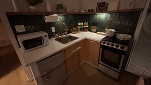 A compact kitchen with a microwave, sink, stove, and cabinets. - Black Diamond Retreat Designer Cabin Hot Tub (Big Bear)