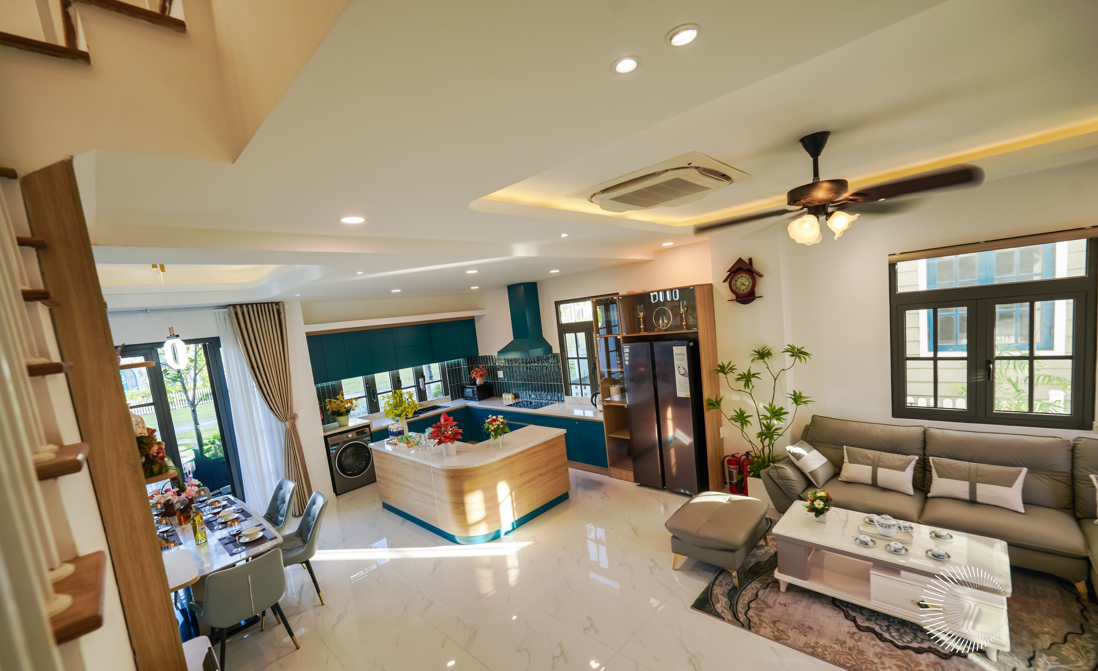 A modern living area with a reception desk, a sofa, a coffee table, and a dining table with chairs.