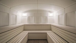 Una sauna con bancos y suelo de baldosas.