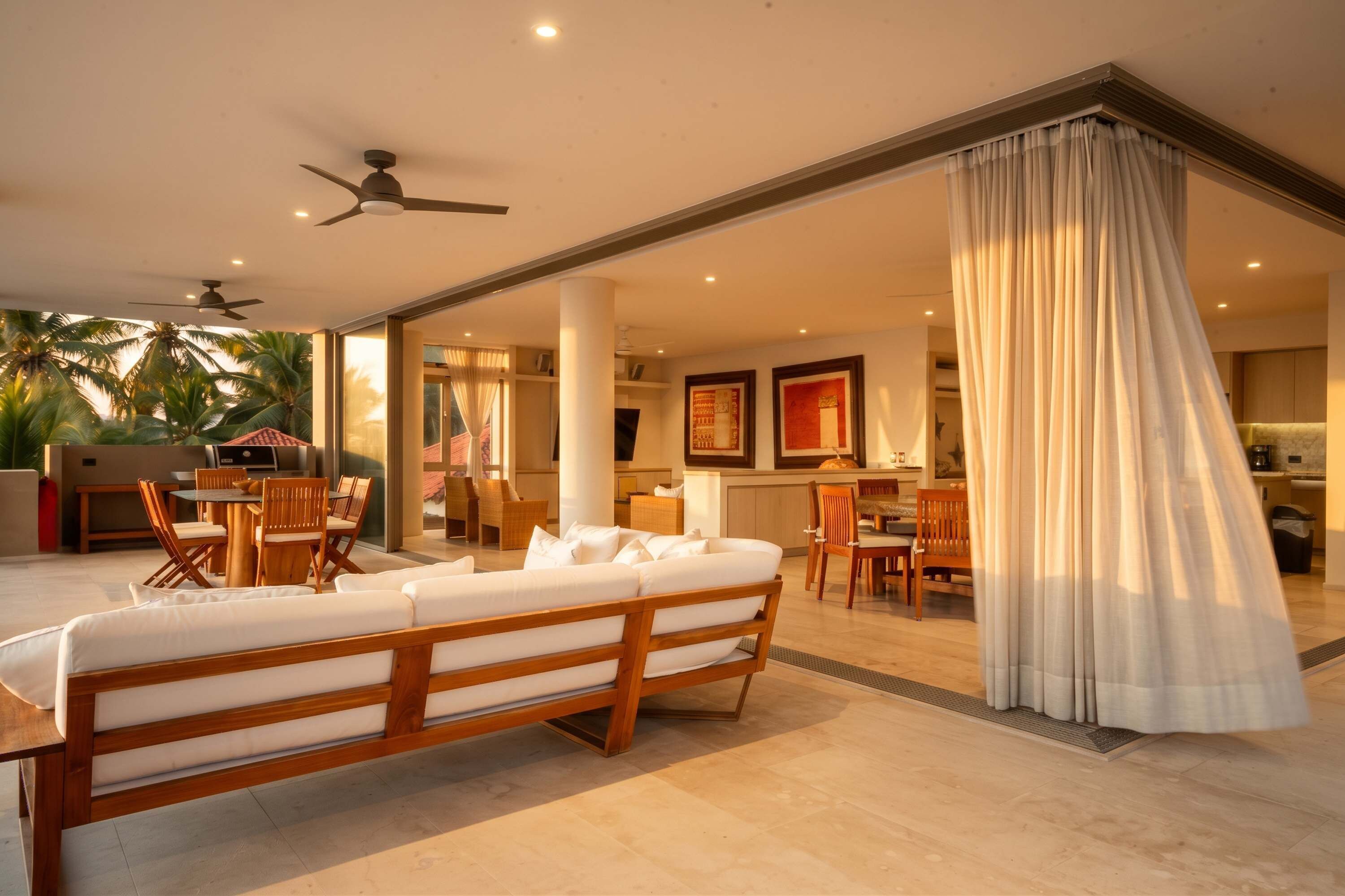 A modern living room with a sofa, dining area, and kitchen.