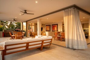 Ein modernes Wohnzimmer mit Sofa, Essbereich und Küche.