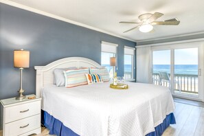 A bedroom with a bed, a nightstand, a lamp, a ceiling fan, and a view of the ocean. - Spacious Beachfront House, Breathtaking Ocean Views, Near Historic Attractions, $300 in Free Tickets (St. Augustine)