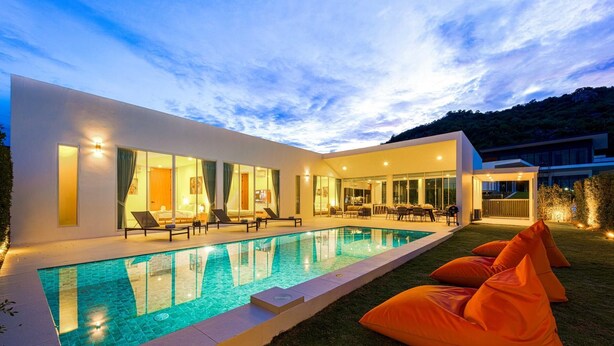 Une maison moderne dotée d’une piscine, d’un espace extérieur aménagé et d’un intérieur bien éclairé.