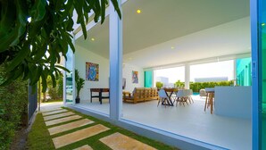Un intérieur moderne comprenant un coin repas, des canapés et une vue sur la piscine.