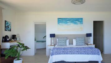 Quarto com cama, mesas de cabeceira, luminária, planta e um quadro na parede.