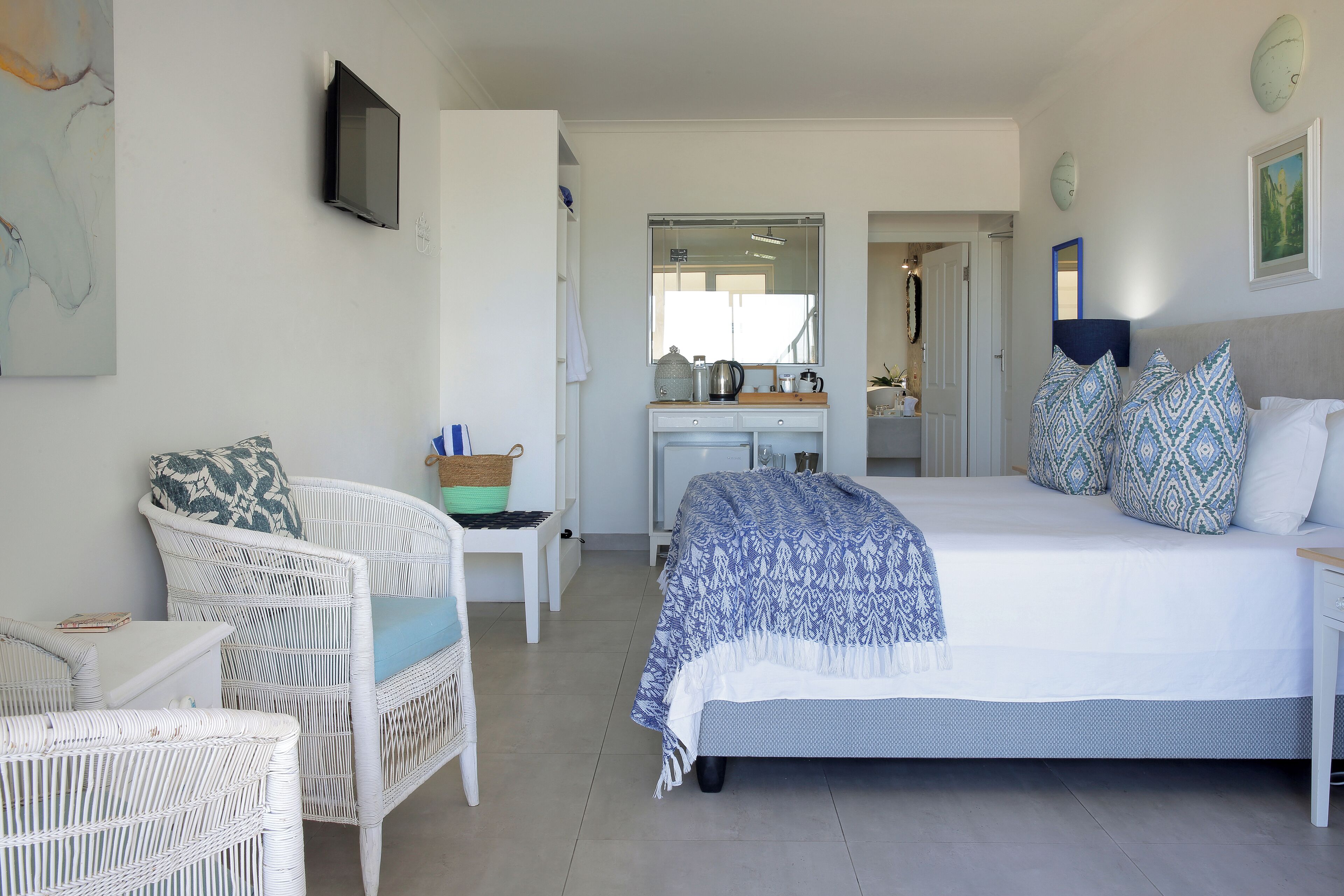 Un dormitorio con una cama grande, un escritorio, una silla y un televisor.