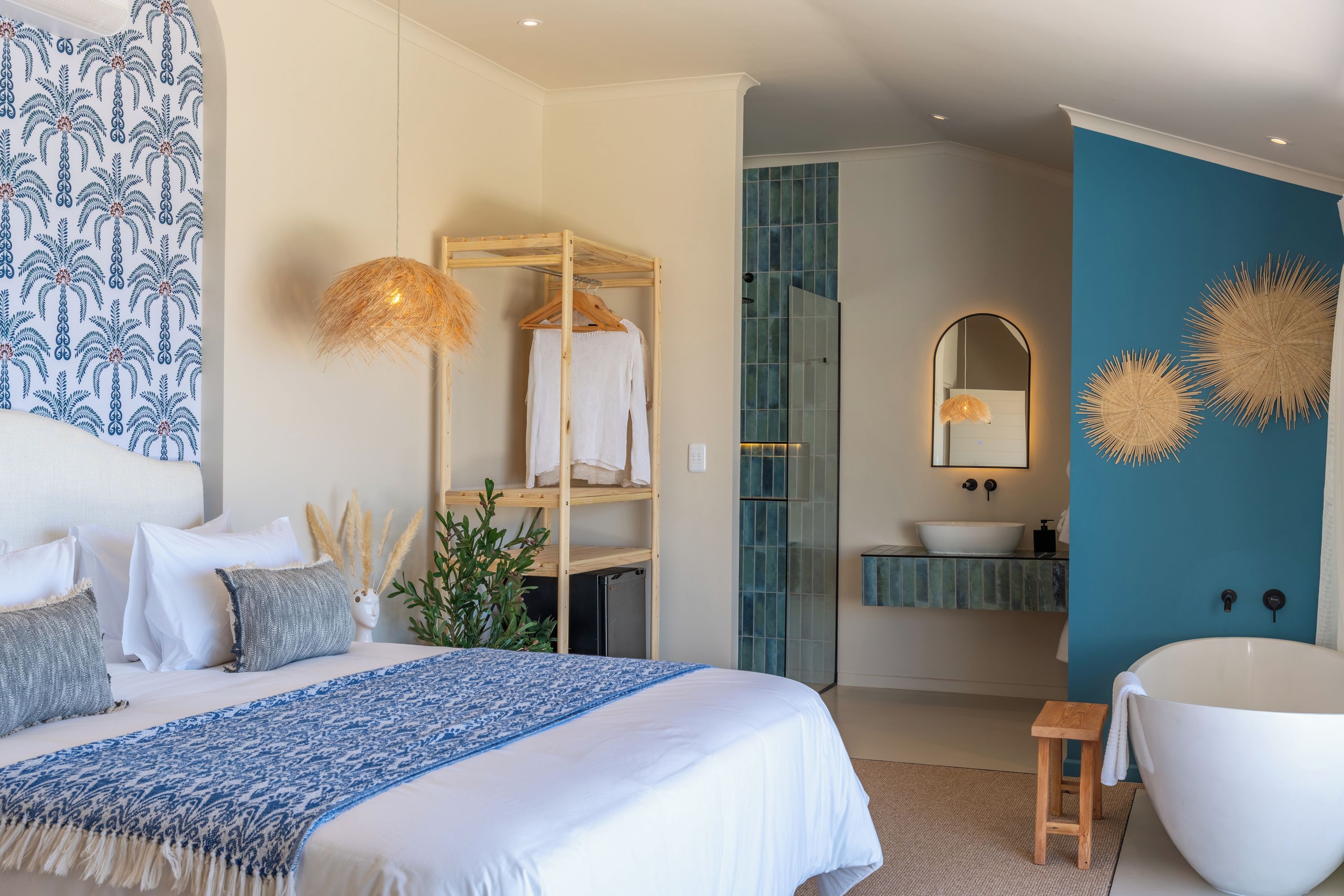 A modern bedroom with a bed, bedside table, and a large window.
