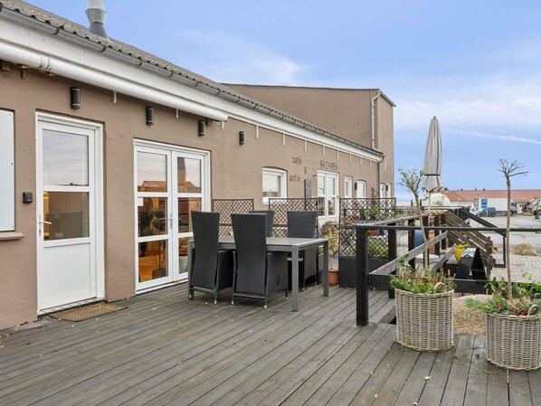 An outdoor café area with wicker furniture and potted plants.