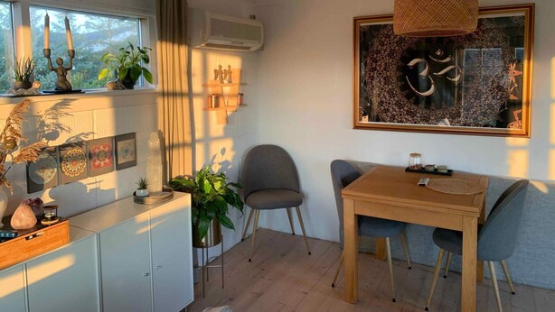 Un comedor acogedor con una mesa de madera, dos sillas y una lámpara colgante.