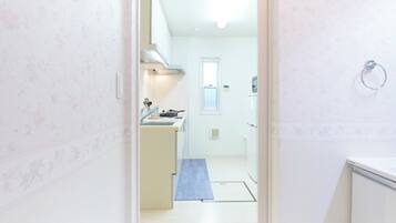 Een koelkast, een magnetron, een kookplaat, kookgerei, borden en bestek