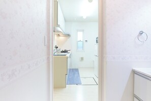 Een koelkast, een magnetron, een kookplaat, kookgerei, borden en bestek