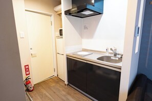 Kylskåp, mikrovågsugn, spishäll och grytor/köksredskap