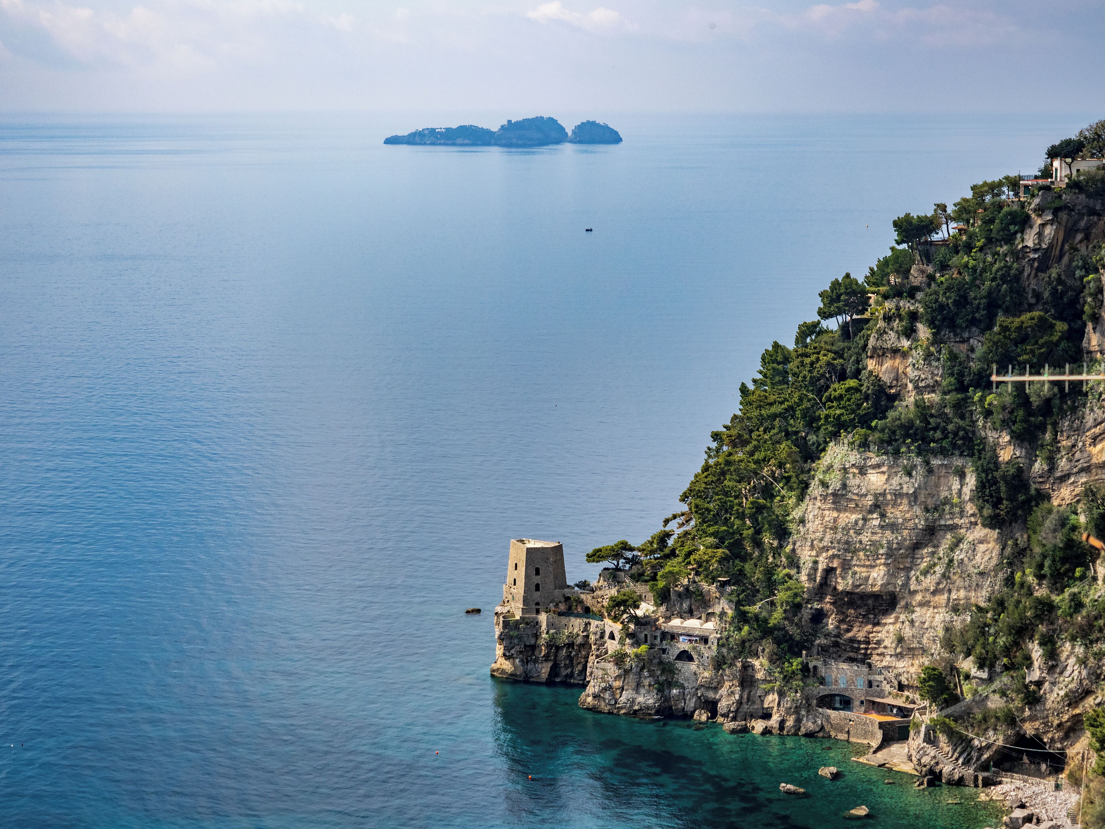 A coastal town with a prominent tower on a cliff overlooking the sea.