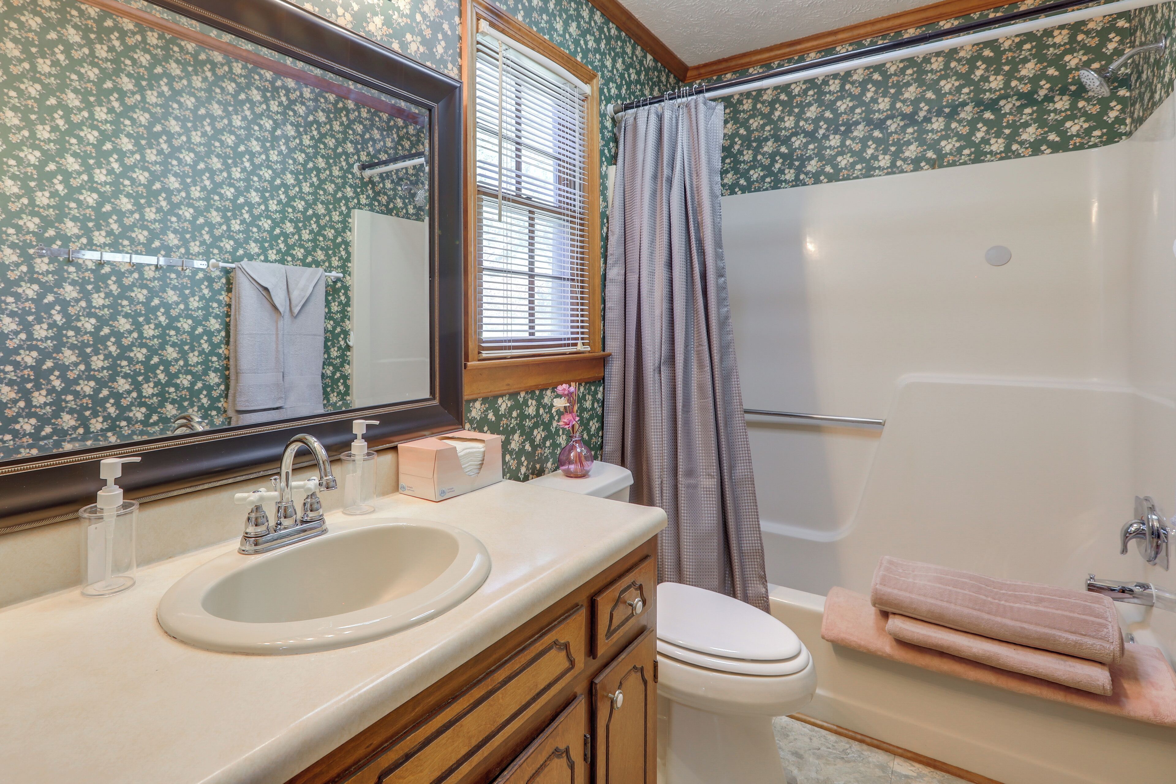 Une salle de bain équipée d’un lavabo, d’un miroir, de toilettes et d’une baignoire.