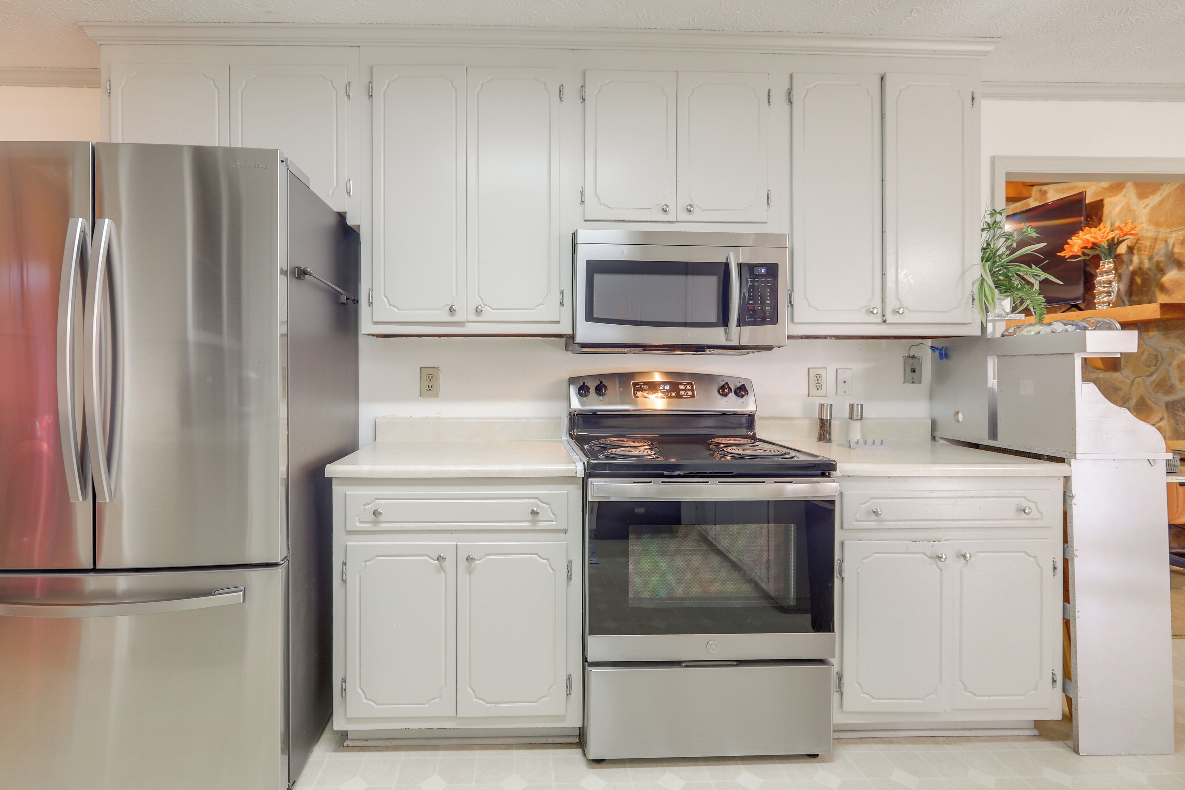 A kitchen with white cabinetry, stainless steel appliances, and a built-in oven.