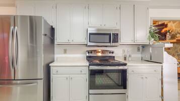 A kitchen with white cabinetry, stainless steel appliances, and a built-in oven.