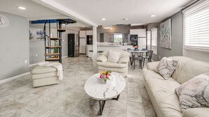 Un espacio habitable amplio con un sofá, una mesa de centro y una mesa de comedor.