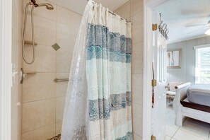 Ein Badezimmer mit Dusche, einem Bett und einem Fenster.