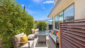 An outdoor patio with a sofa, chairs, and a table. - Designer Palm Springs Retreat | Private Spool · Mtn Views · 3BR · Pets Welcome (Palm Springs)