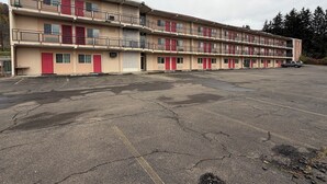Un motel de varios pisos con puertas rojas y balcones.