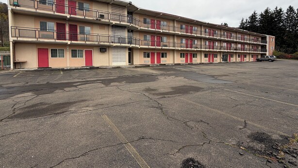 Un motel de varios pisos con puertas rojas y balcones.
