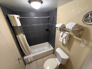 A bathroom with a bathtub, toilet, and towel rack. - Kiteville Bradford (Bradford)