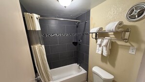 Un baño con bañera, inodoro y cortina de ducha.
