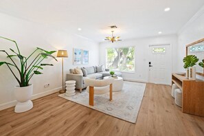 Un salon moderne avec un canapé, une table basse et une plante en pot.