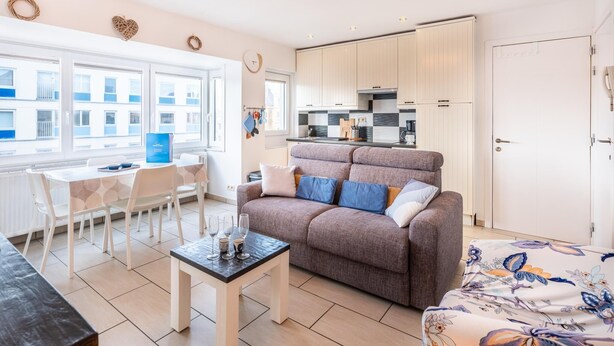 Un apartamento moderno con comedor, sofá y cocina.