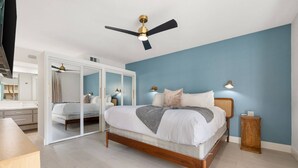 A bedroom with a bed, a ceiling fan, a nightstand, and a mirror. - Gorgeous Iconic Villa Alejo Condo, One Block from Downtown (Palm Springs)