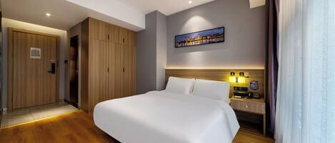 Une chambre d’hôtel moderne avec un grand lit, une armoire en bois et une table de chevet avec une lampe.