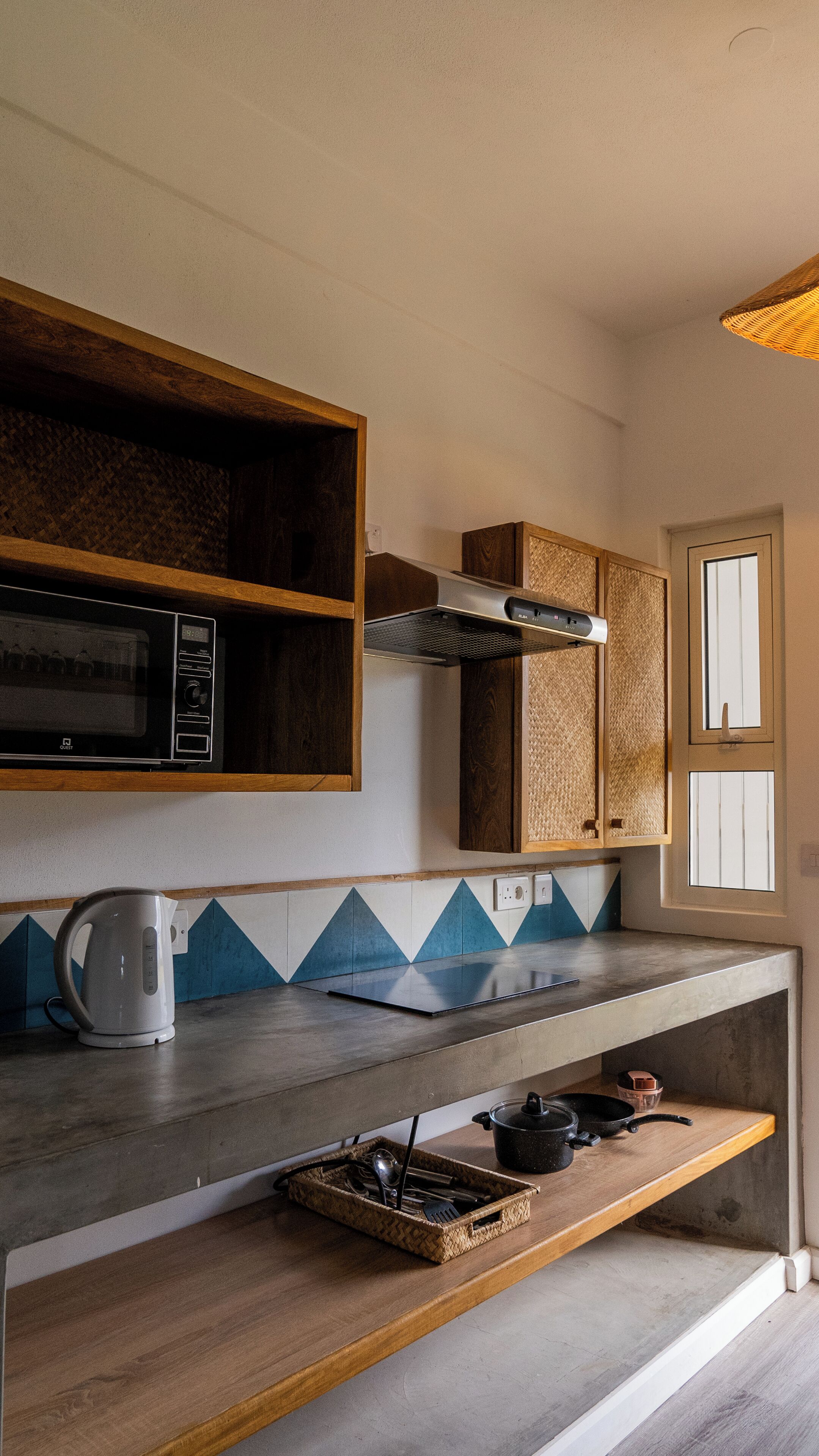 Una cocina compacta con microondas, hervidor y un pequeño fregadero.