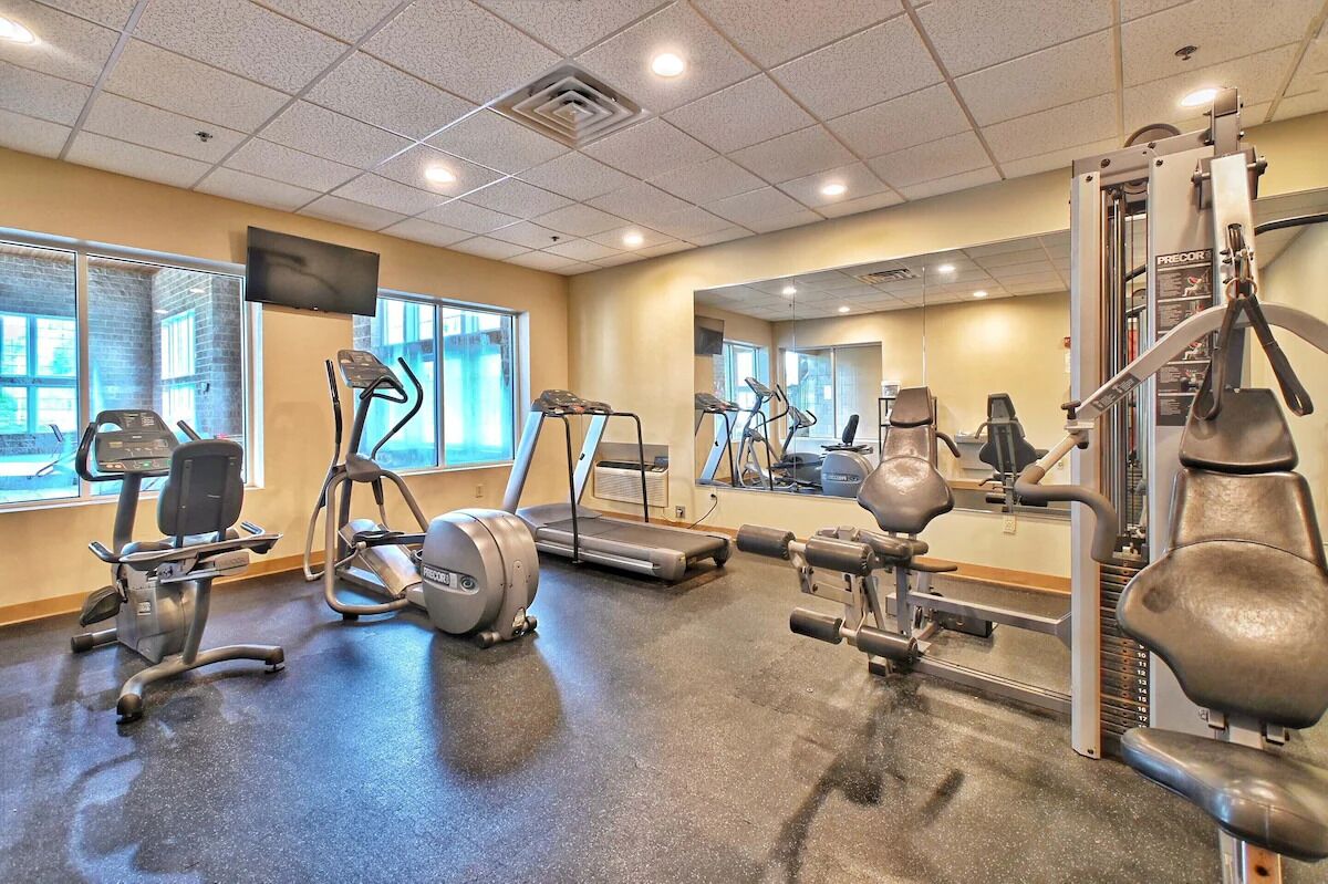 A gym with treadmills, elliptical machines, and weight equipment.