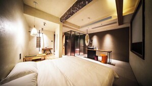 A modern hotel room with a large bed, a desk with a chair, a mirror, and a small table with a lamp. - NO.9 Alley Yuchen Res Dence (Guilin)