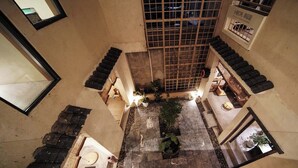 A courtyard with a tiled floor, potted plants, and a wooden staircase. - NO.9 Alley Yuchen Res Dence (Guilin)