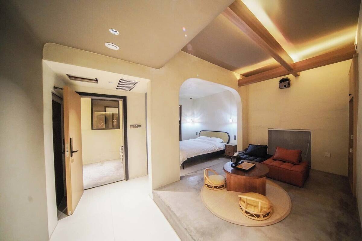 Ein modernes Hotelzimmer mit einem Bett, einer Couch, einem Couchtisch und einer kleinen Essecke.