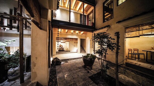 A multi-level building with a courtyard, wooden beams, and potted plants. - NO.9 Alley Yuchen Res Dence (Guilin)