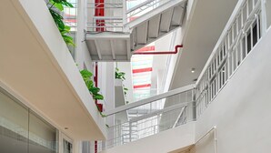 Een meerlaags interieur met glazen wanden, houten vloeren en een centrale trap.