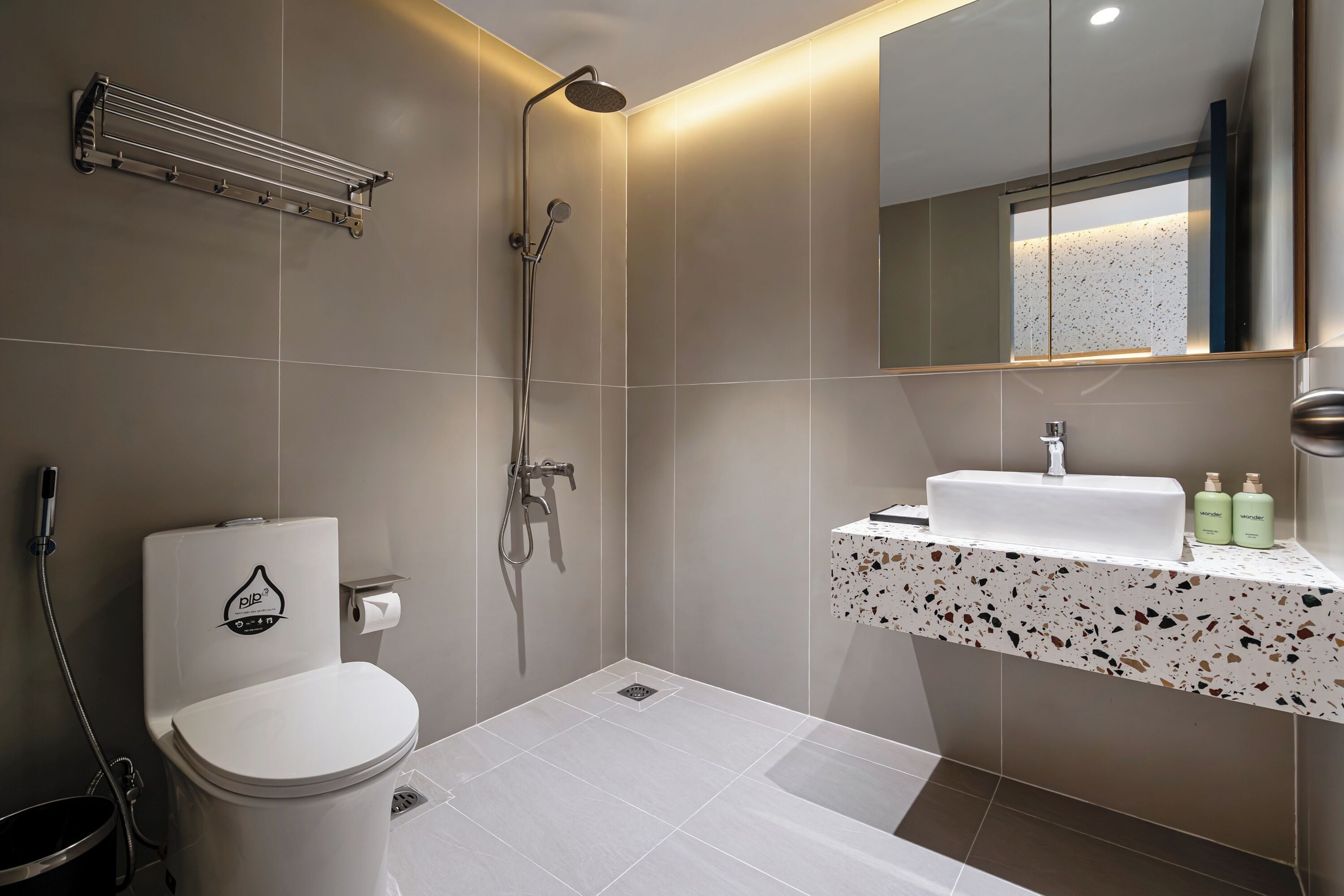 A modern bathroom with a toilet, shower, and sink.