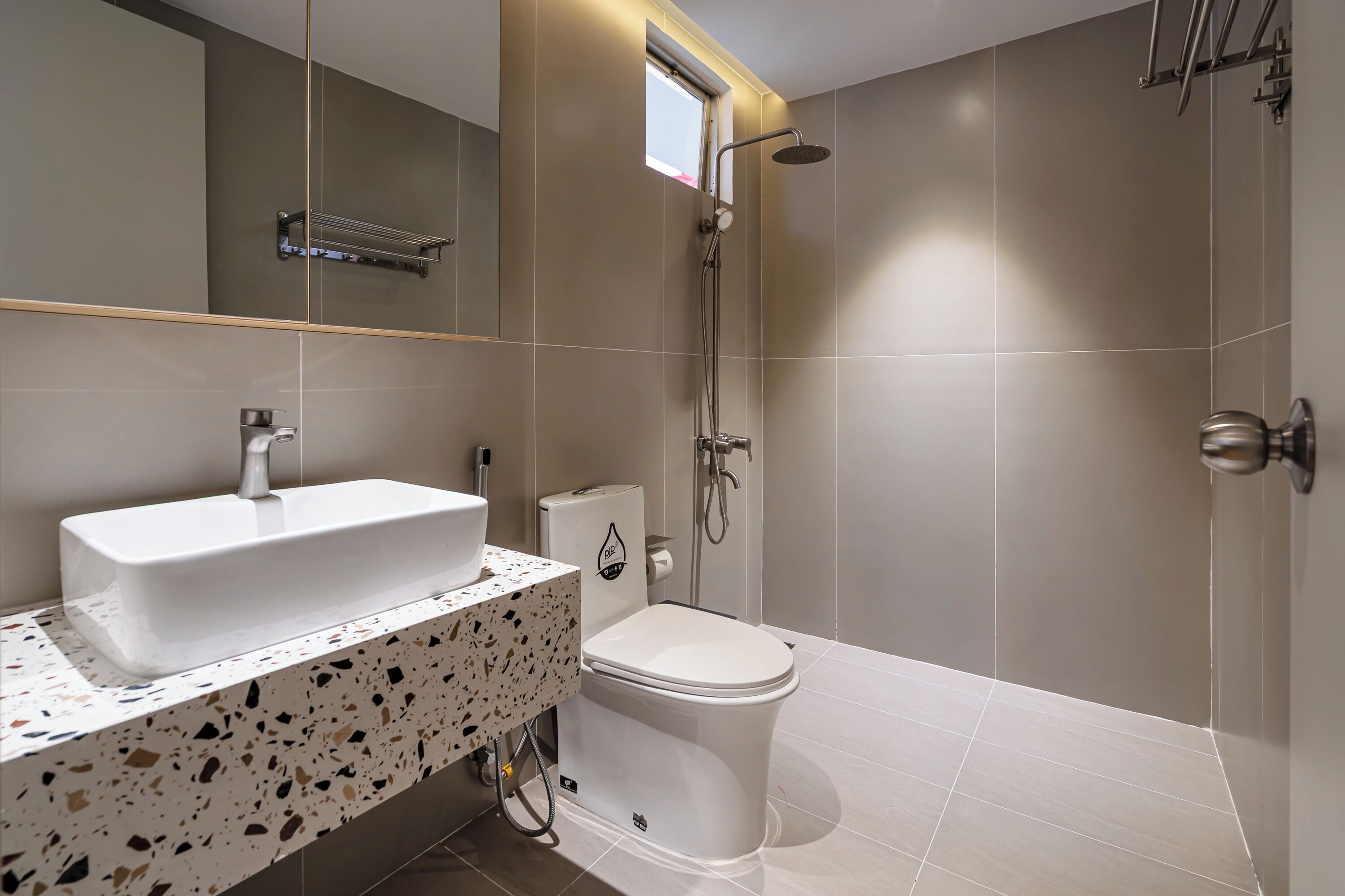 A modern bathroom with a white sink, toilet, and shower.