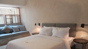 Une chambre moderne avec un grand lit, un canapé et une petite table ronde.