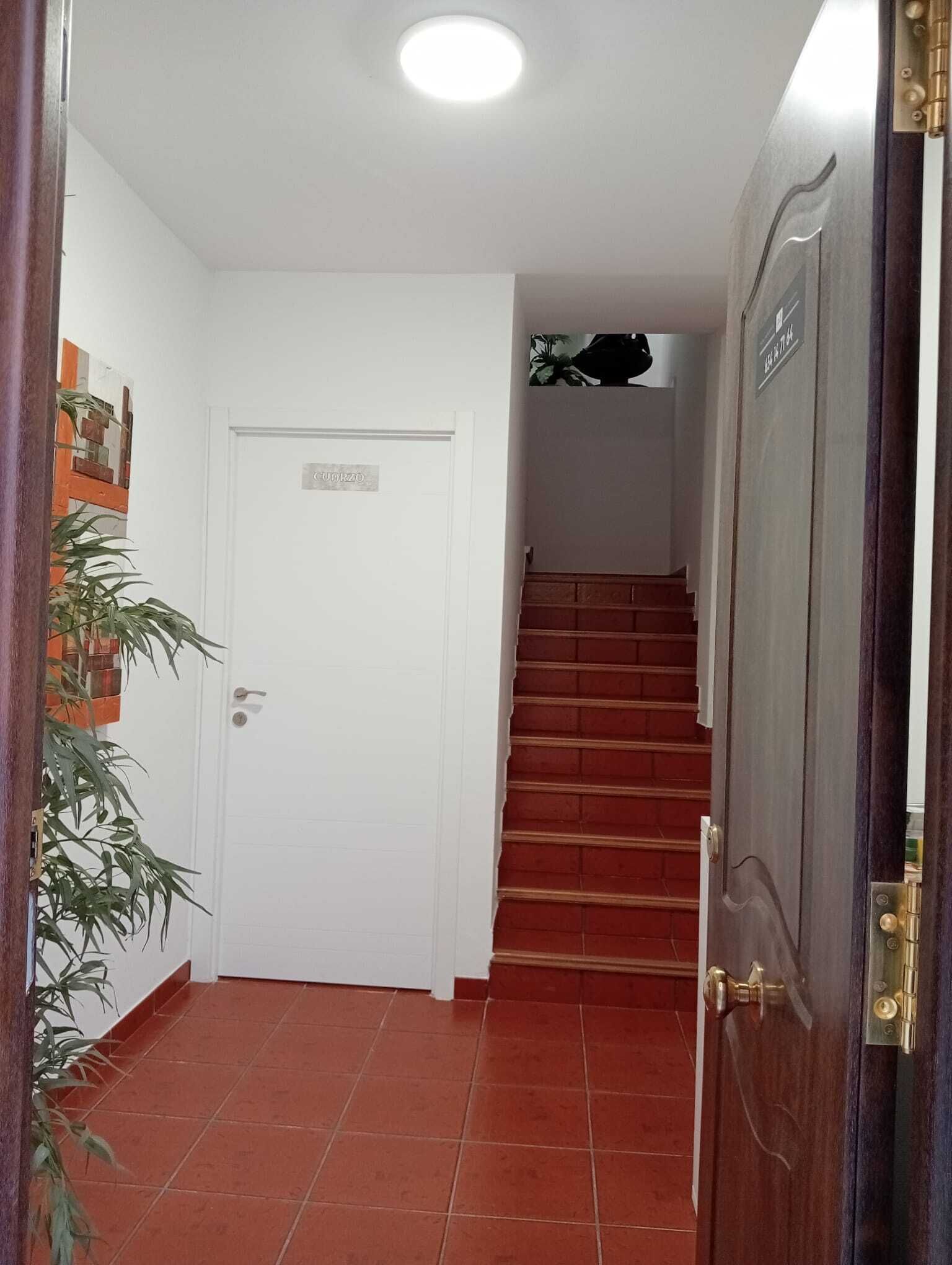 A staircase leading to a room with a white door and a sign that reads "CUIRZO".